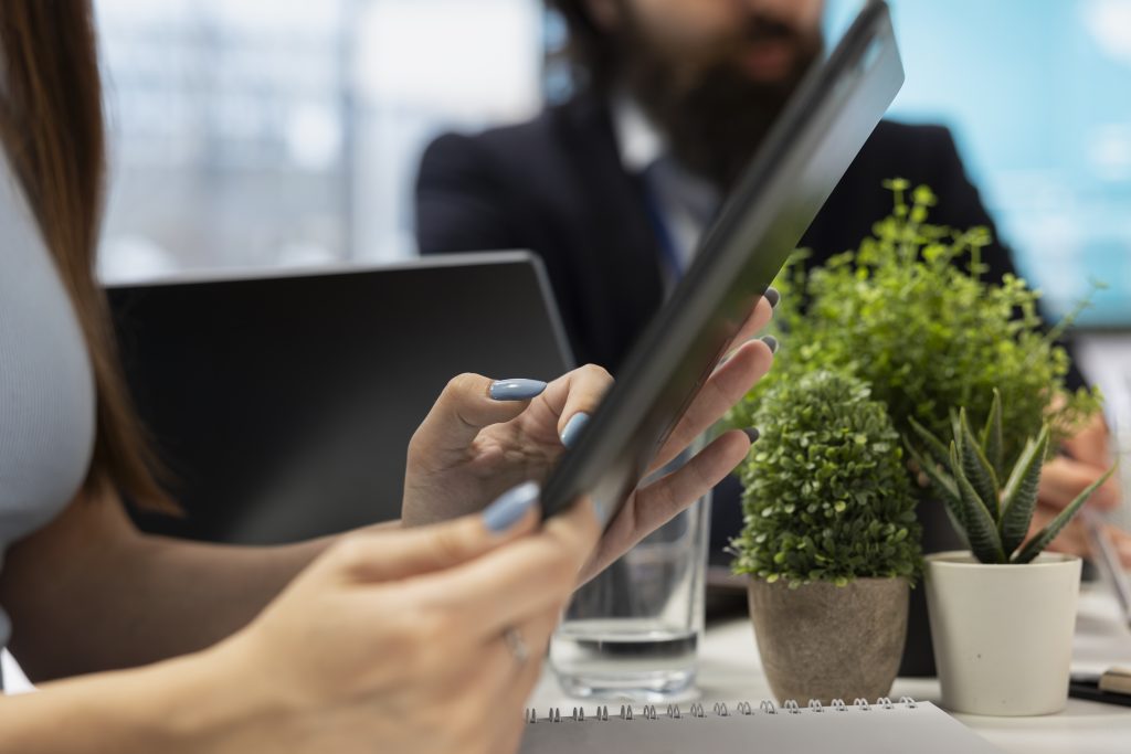 woman reading diagrams on tablet device, helped by specialist